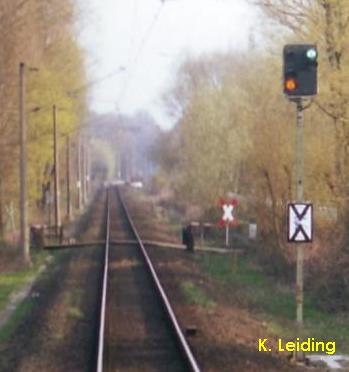 Vorsignal und Bahnbergang.