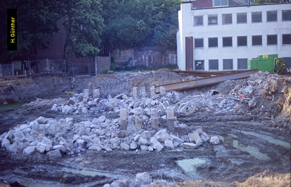 Das weiße Gebäude in Bildmitte besitzt eine abgeschrägte Wand zur Hochbahntrasse hin.